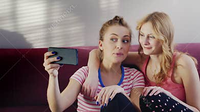Two young women talking on the video chat. Positive emotions, waving their hands in phone camera