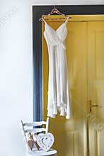 White dress hanging on peg