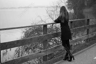 The woman dressed in black looking at the lake