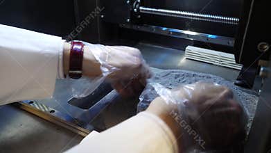 3D printed iron product. Young designer engineer using a 3D printer in the laboratory and studying a product prototype