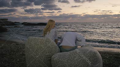 Young man and woman quarrels on the beach of the ocean