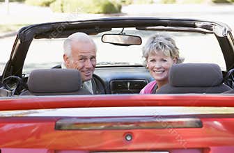 Couple in convertible car smiling