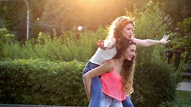 Funny girlfriend. Girl holds the girlfriend on piggyback.