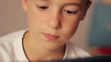 Handsome young boy using touchscreen tablet