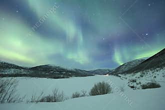 Aurora borealis over snowy winter landscape, Finnish Lapland