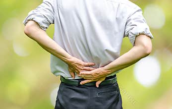 Close up of a man holding his back in pain