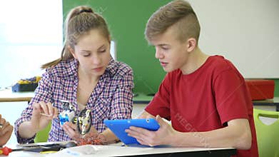 Students building a robot using a digital tablet