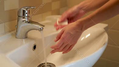 Girl washes her hands under the tap