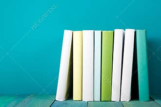 Row of colorful books, grungy blue background, free copy space
