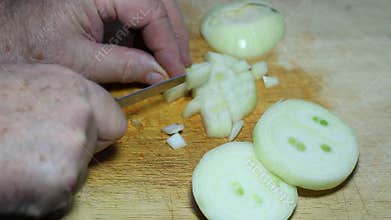 Slicing an onion on a wooden board.