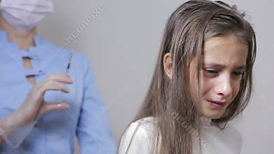 Little girl is afraid of the doctor with a syringe. baby cries afraid injection