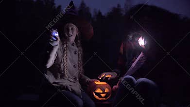 Two teenagers playing with lights on Halloween night