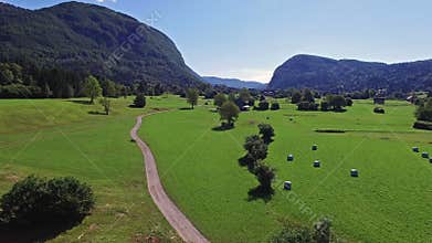 4K. Flight above green valley near Bohinj Lake in the morning. Road to the Stara Fuzina village in Julian Alps. Triglav NP.