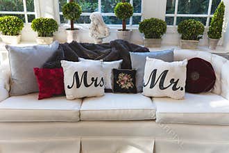 Mr and Mrs pillows on a couch at a wedding reception