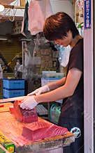 Young man cuts Tuna meat at Tsukiji Fish Market.
