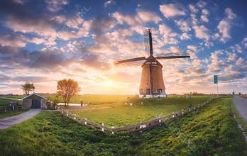 Windmill at sunrise in Netherlands. Spring panoramic landscape