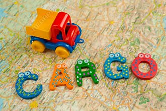 A toy truck carries a cargo on a table with a map and a notepad.