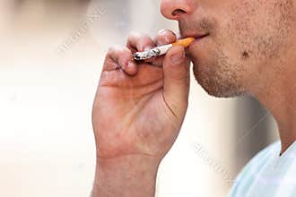 Adult man smoking cigarette outside