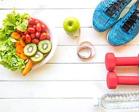 Healthy lifestyle for women diet with sport equipment, sneakers, measuring tape, vegetable fresh, green apples and bottle of water