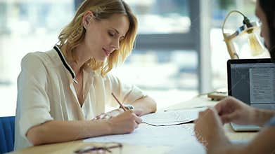 Focused girl listening to groupmate explaining her educational material