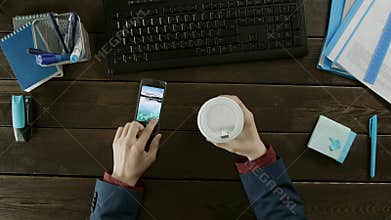 Top down view of a man choosing a new wallpaper on his cellphone