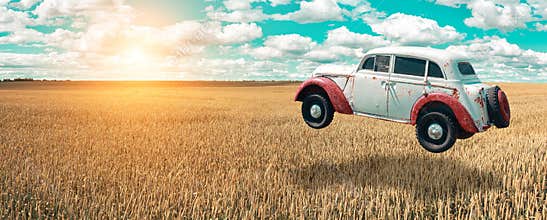 Flying car soars into the sky. Retro automobile hovers in the air above a golden wheat field on the background of blue sky.