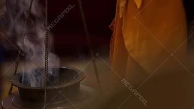 A buddhist monk holds incense