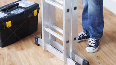 Close up of man bringing tool box and ladder