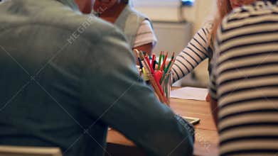Casual business team taking note during meeting