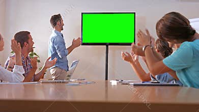 Creative team looking at television with green screen