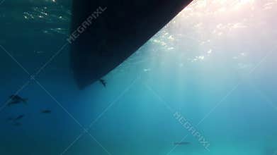 Bottom of boat out of water on background of sun