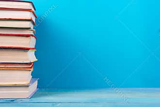 Stack of colorful books, grungy blue background, free copy space