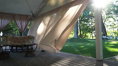 Curtains slowly blowing back from the wind.