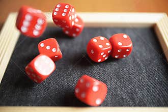 Several rolling red dice fall on special boardgame frame