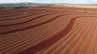 Aerial footage red soil farm plowing