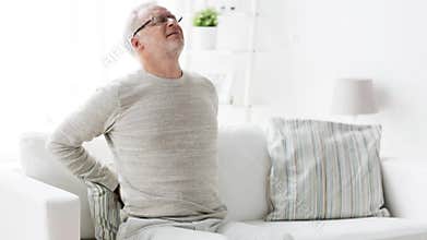 Unhappy senior man suffering from backache at home 104