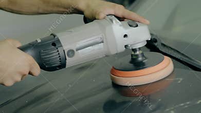 Close up shot Worker polish black car with special tools