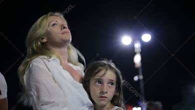 Mother comforting crying daughter outdoor. Mom and daughter at night
