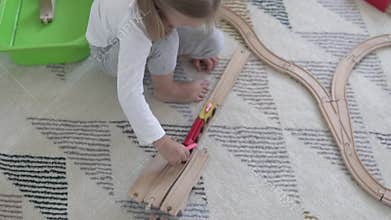 Children build a toy wooden road at home