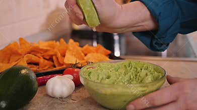 Making guacamole - hands squeezing a lime
