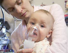 Sick baby with nebulizer mask