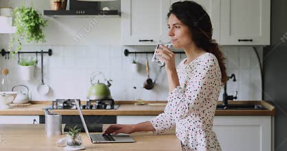 Woman working on laptop take break drinking mineral water