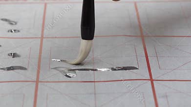 Learning a Chinese calligraphy brushes on water writing practice paper in class room