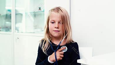 Portrait of little girl listening breathing and heartbeat through stethoscope