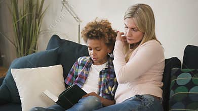 Happy family is reading together story from book which holding little boy.