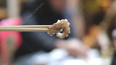 Chopsticks tong octopus tentacle. Famous korean food
