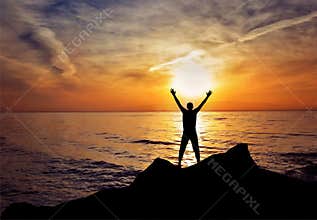 Man silhouette hands up in the air freedom success