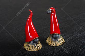 Ceramic Christmas elves in red hats on a black background
