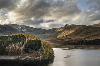 Stunning Autumn Fall landscape of Hawes Water with epic lighting and dramatic sunlight in Lake District