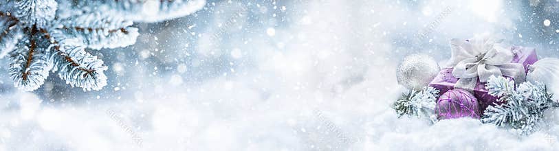 Purple christmas gift and balls on snow with fir branches. Merry Xmas concept- panoramic banner